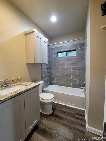 a bathroom with a granite countertop toilet a sink and bathtub