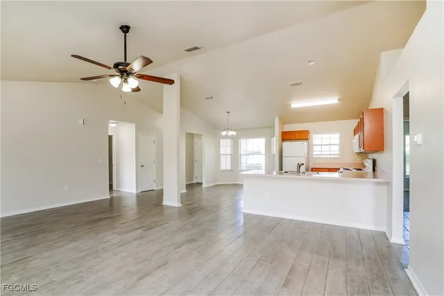 a view of an empty room and kitchen view