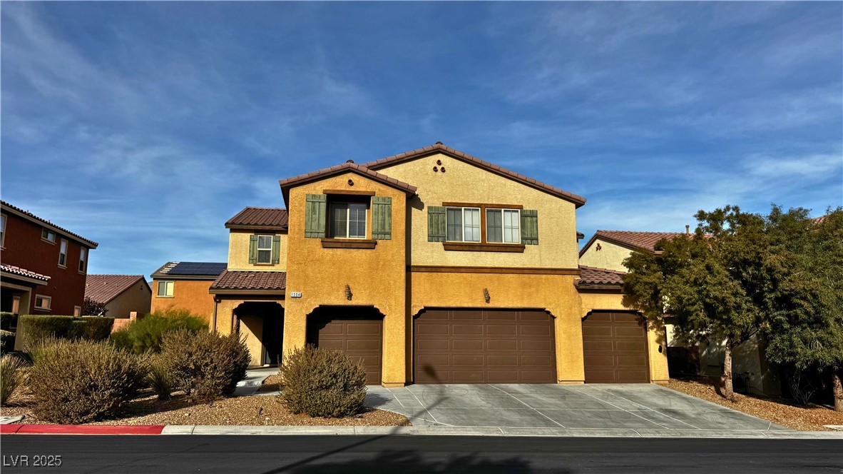Mediterranean / spanish-style house with driveway, stucco siding, a tile roof, and an attached garage