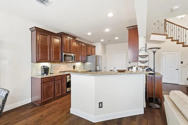 a kitchen with kitchen island granite countertop wooden cabinets and white appliances
