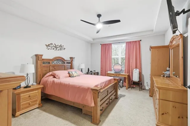 a bedroom with a bed and large windows