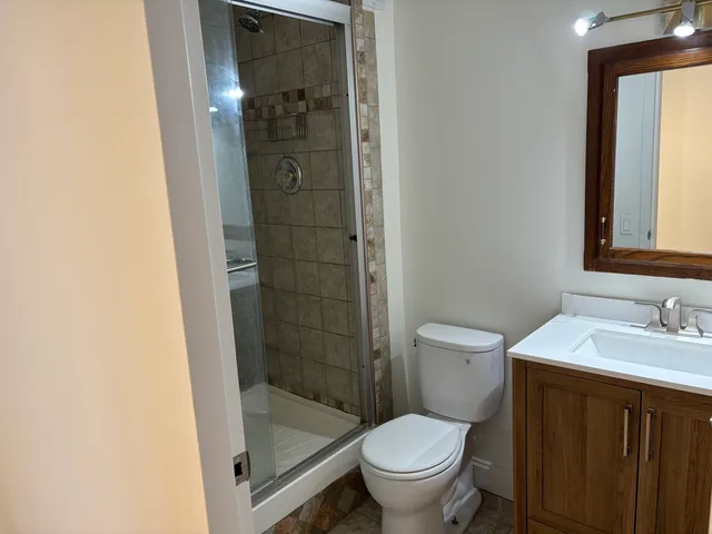 a bathroom with a granite countertop sink toilet and shower