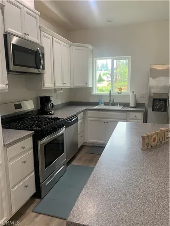 a kitchen with stainless steel appliances granite countertop a stove a sink and a microwave