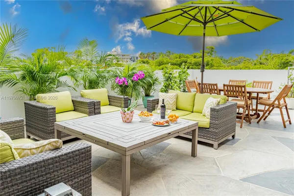 a view of an outdoor sitting area with furniture and umbrella