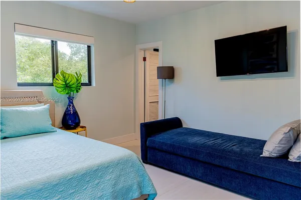 a bedroom with a bed and a flat screen tv