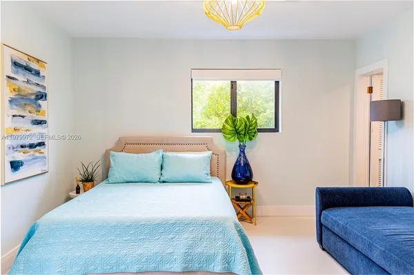 a bedroom with a bed and a potted plant