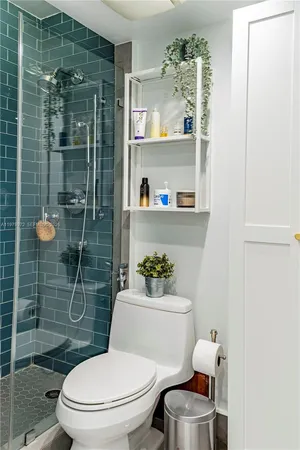 a white toilet sitting next to a bathroom and shower