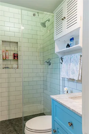 a bathroom with a sink a toilet and shower