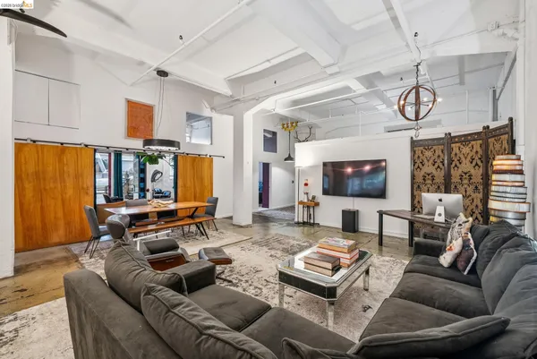 a living room with furniture kitchen view and a large window