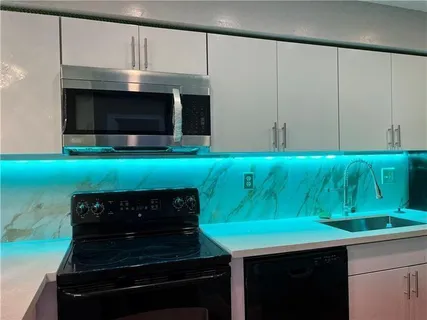 a kitchen with kitchen island a sink stainless steel appliances and cabinets