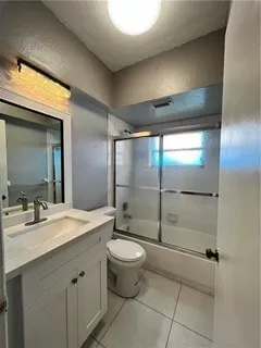 a bathroom with a double vanity sink toilet and shower