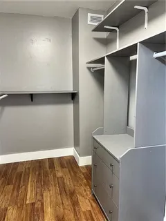 a view of walk in closet with wooden floor