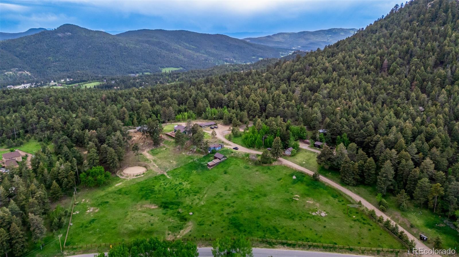 8537 Doubleheader Ranch Road Morrison, CO 80465 - Photo 2 of 48 a view of a lush green hillside and a building