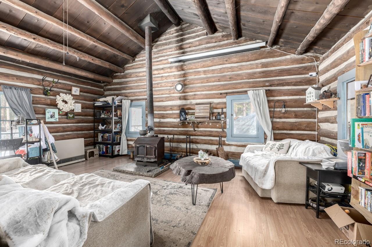 8537 Doubleheader Ranch Road Morrison, CO 80465 - Photo 35 of 48 a bedroom with furniture and a wooden floor