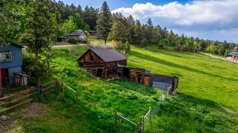 an aerial view of a house with pool big yard and large trees
