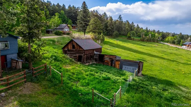 an aerial view of a house with pool big yard and large trees