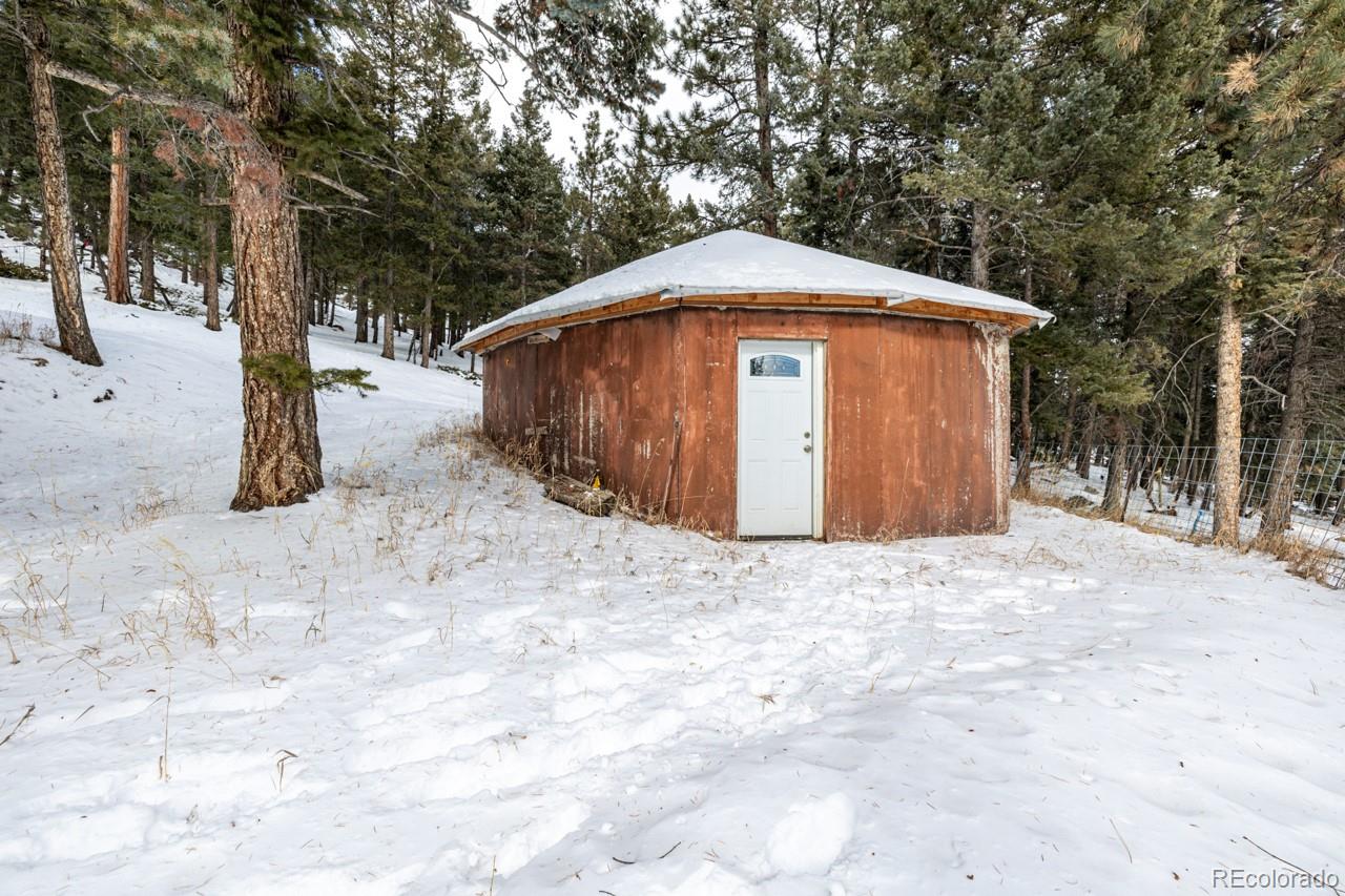 8537 Doubleheader Ranch Road Morrison, CO 80465 - Photo 41 of 48 a backyard of a house with large trees