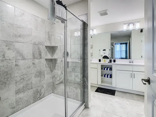 a bathroom with a shower sink and mirror