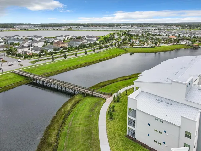 an aerial view of a residential houses with outdoor space and ocean view