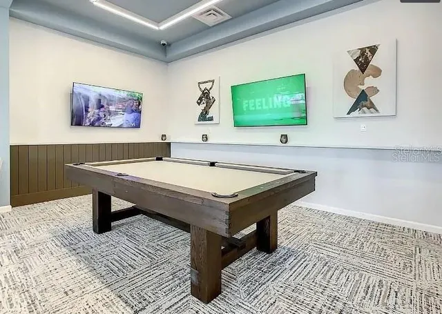 a room with pool table and wall paintings