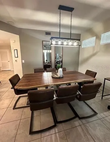 a room with table chairs and flat screen tv