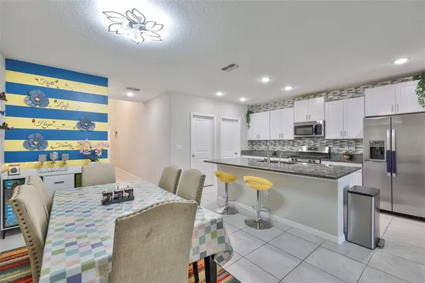 a large kitchen with a table chairs wooden cabinets and appliances