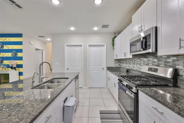 a kitchen with stainless steel appliances granite countertop a sink stove and cabinets