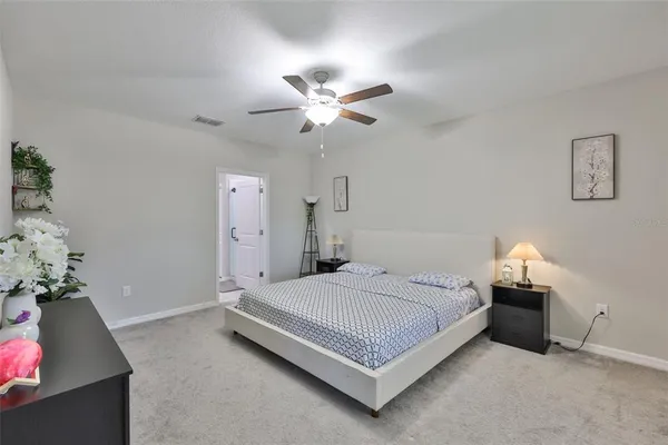 a bedroom with a bed and a chandelier fan