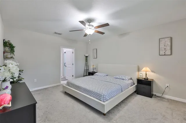 a bedroom with a bed and a chandelier fan