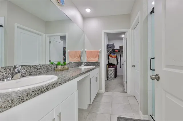 a en suite bathroom with a granite countertop sink and a mirror