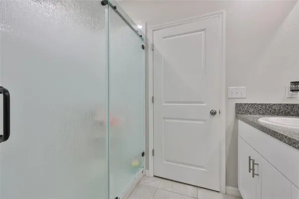 a bathroom with a granite countertop sink and shower
