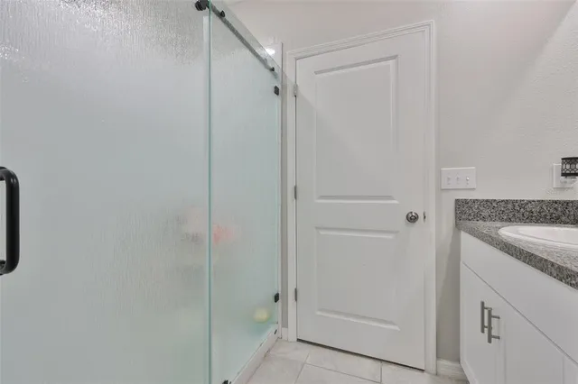a bathroom with a granite countertop sink and shower
