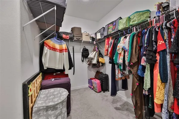 a view of walk in closet with clothes and shoes