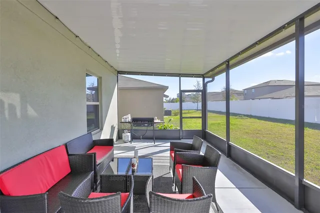 a living room with furniture and a floor to ceiling window