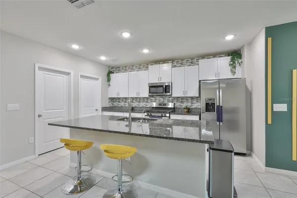 a kitchen with stainless steel appliances granite countertop a refrigerator and a stove top oven