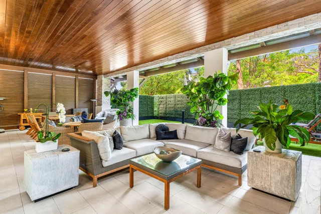 a living room with patio furniture and a potted plants