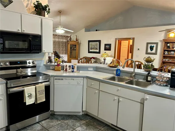 a kitchen with sink cabinets and flat screen tv