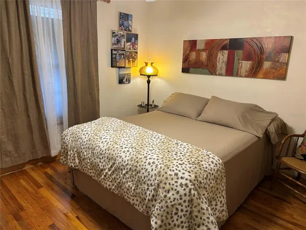 a bedroom with a bed and wooden floor