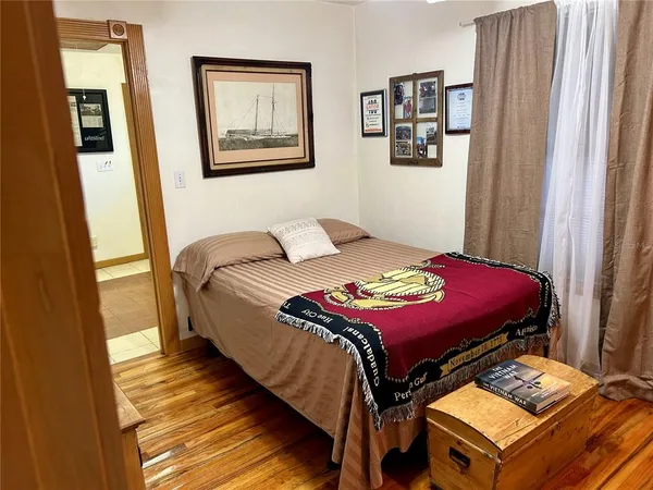 a bedroom with bed and wooden floor