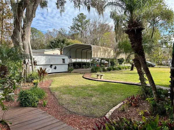 a view of a backyard with plants and a patio