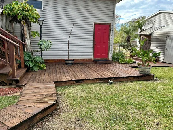a view of a house with a small yard and potted plants