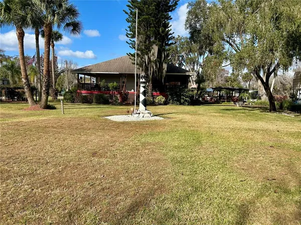 a backyard of a house with lots of green space and fountain