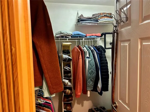 a view of walk in closet with clothes and shoes