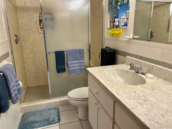 a bathroom with a granite countertop sink a mirror and a toilet