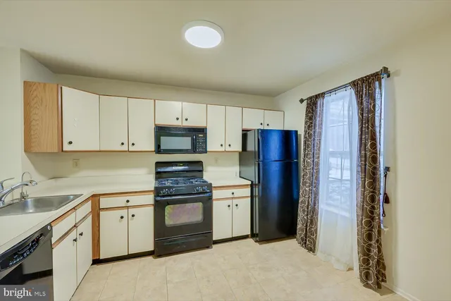 a kitchen with a refrigerator sink and cabinets
