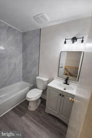 a white toilet sitting next to a bath tub
