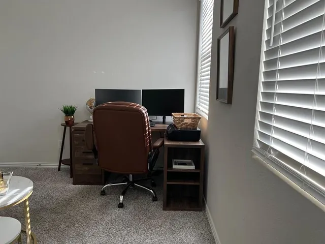 a view of a workspace with furniture and a window