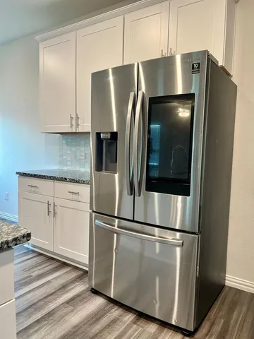 a metallic refrigerator freezer sitting in a kitchen