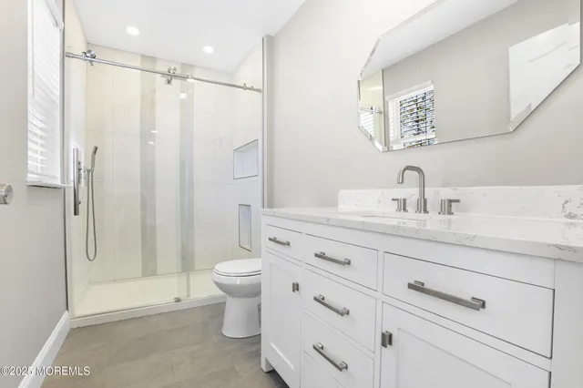 a bathroom with a shower toilet sink and mirror