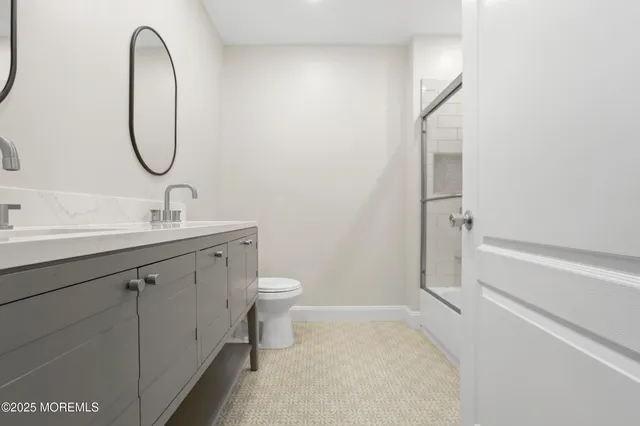 a bathroom with a granite countertop sink a toilet and a mirror